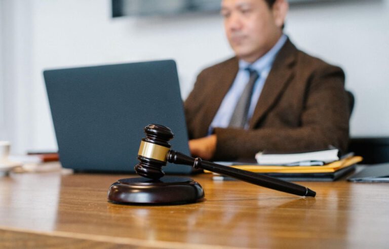 Man sitting behind a desk with a gavel on it.